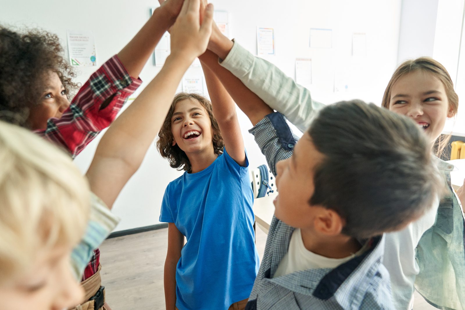 A group of kids celebrating together with a high five