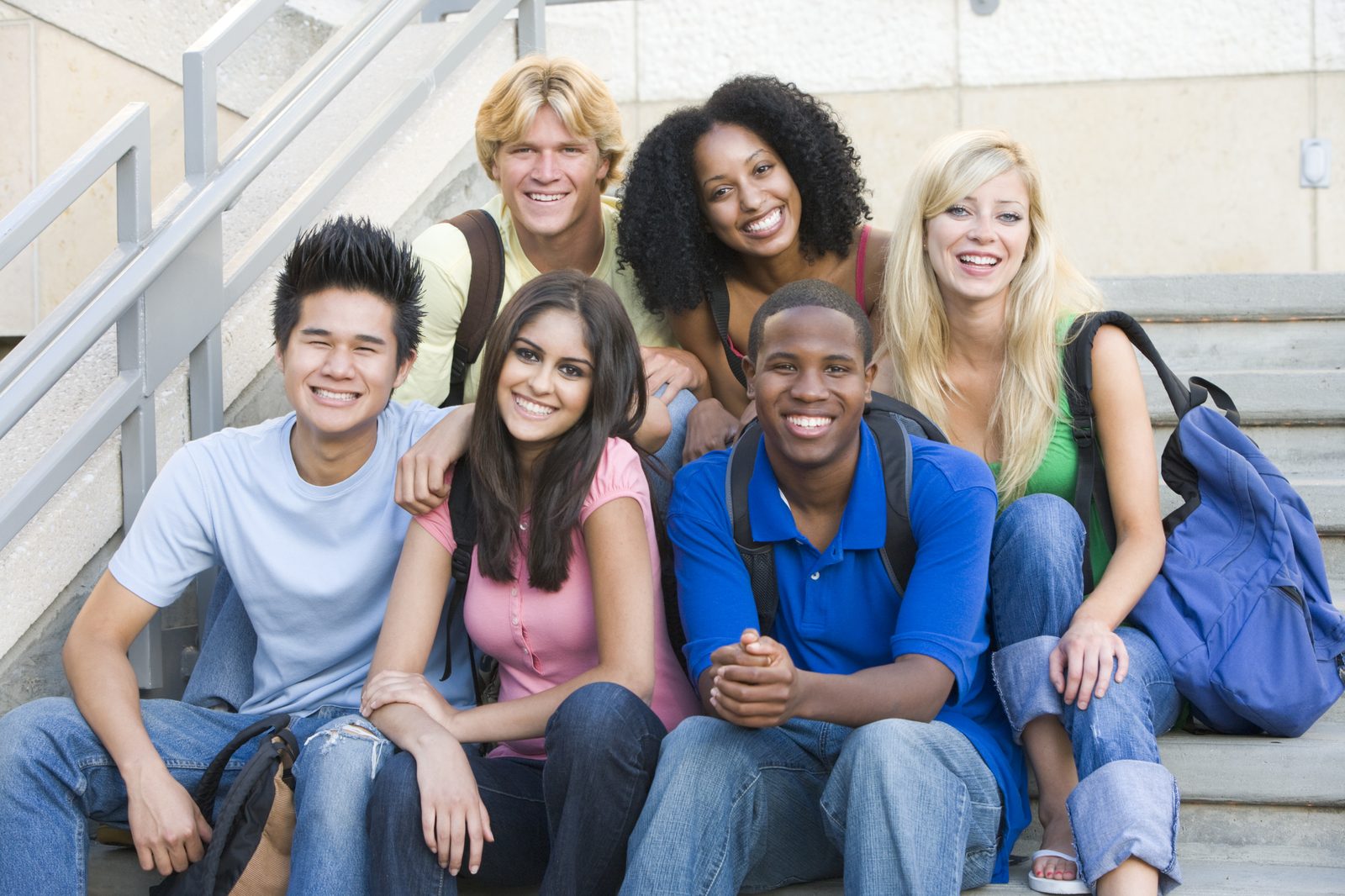 A diverse group of teens and young adults smiling together